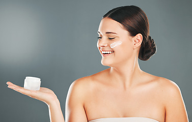 Image showing Woman apply cream for face, happy with smile and beauty, skincare and moisturizer isolated on studio background. Sunscreen, lotion and healthy skin with glow, wellness and facial treatment product