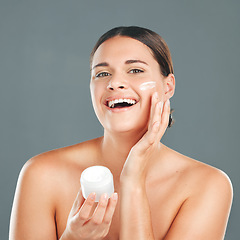 Image showing Woman apply cream for face, happy in portrait and beauty, skincare and moisturizer isolated on studio background. Sunscreen, lotion and healthy skin with glow, cosmetics and facial treatment product