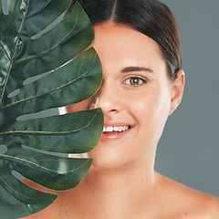 Image showing Palm leaf, face and woman in portrait with smile, beauty and skincare with natural cosmetics isolated in studio background. Healthy skin, wellness and glow, facial and eco friendly cosmetic treatment