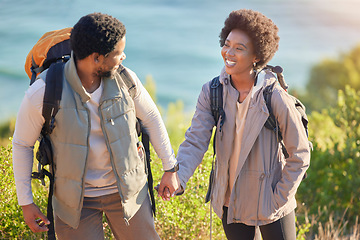 Image showing Black couple, happy and holding hands on hike journey for outdoor exploration, sightseeing and togetherness. Happiness, love and care of people trekking with backpack and smile for travel freedom.