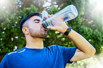 Image showing Nature, drink and runner with water in bottle, relax for thirst on fitness workout in park. Health, exercise and freedom, man drinking in forest while on marathon training run in jungle in Brazil.