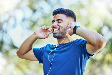 Image showing Listening to music, fitness and exercise man with earphones outdoor at park for cardio training. Happy sports person or athlete in nature with podcast for a run and workout for health and wellness