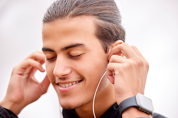 Image showing Closeup, fitness and outdoor with earphones, motivation and workout for wellness, healthy lifestyle and music. Zoom, male and athlete with headphones, smile and podcast with exercise and determined