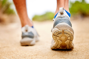 Image showing Fitness, shoes and sports person walking, running and man training on path. Back closeup of runner, feet and sneakers on ground for exercise, park workout and outdoor trekking, hiking and wellness