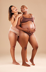 Image showing Pregnant body, bonding or laughing women on studio background in health empowerment, baby support or community. Smile, happy and pregnancy friends in underwear in funny, comic or family planning joke