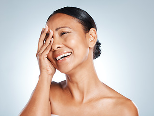 Image showing Laughing, hand and woman in studio for skincare, hygiene and grooming against grey background. Beauty, joy and Mexican lady model relax with wellness, routine and skin treatment, posing and isolated