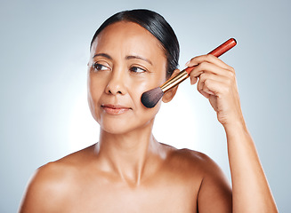 Image showing Cosmetics, senior woman and brush for dermatology, beauty and lady on grey studio background. Makeup tools, mature female and foundation for face, natural care and wellness for smooth and clear skin