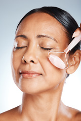 Image showing Face, elderly woman with roller and massage, antiaging skincare with beauty zoom isolated on studio background. Facial, cosmetic tools and dermatology with natural cosmetics and skin wellness