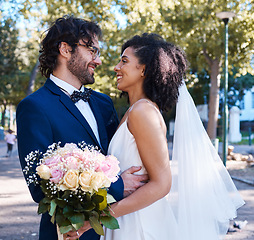 Image showing Interracial wedding and couple with flowers and hug at romantic outdoor marriage event celebration together. Partnership, commitment and trust embrace of happy bride and groom with smile.