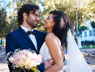 Image showing Interracial love and couple wedding with flowers for romantic outdoor marriage event celebration together. Partnership, commitment and trust embrace of happy bride and groom with excited smile.