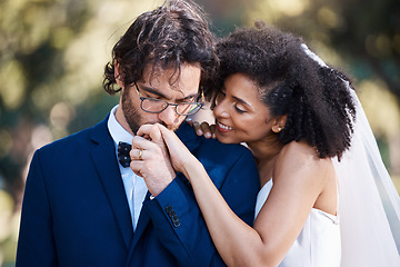 Image showing Wedding, kiss on hand and happy couple outdoor for marriage celebration event together with commitment. Interracial man and woman at ceremony with trust, partnership and respect with smile from bride