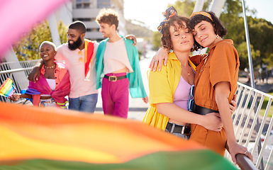 Image showing Lgbt, city and couple of lesbian friends hug with rainbow flag for support, queer celebration and parade for love. Diversity, lgbtq community and group of people enjoy freedom and pride identity