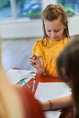 Image showing Creative kids sitting in a preschool institution, draw and have fun while they get an education