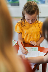 Image showing Creative kids sitting in a preschool institution, draw and have fun while they get an education