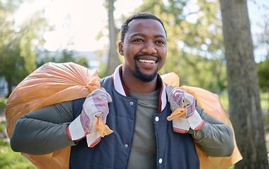 Image showing Volunteer, community service and black man cleaning park with garbage bag for a clean environment. Person helping with trash or garbage for eco friendly lifestyle and recycling outdoor in nature