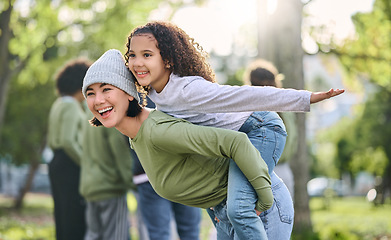 Image showing Mother, piggy back and interracial family fun of a girl and mom together in nature. Park, happy summer and mama with love and care for child playing outdoor in a garden with blurred background