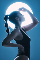 Image showing Beauty, moon and profile of a woman in a studio with a sensual, soft and attractive pose. Cosmetic, magical and slim female model with a glow posing by light while isolated by a blue background