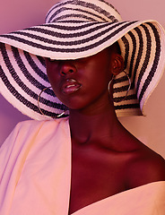 Image showing Model, design and black woman fashion in neon, UV and purple light in studio background wearing a sun hat. Style, makeup and beauty by female with dark skin aesthetic creativity and color