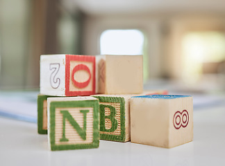 Image showing Wooden blocks, table and letters for learning, education or childhood development at home. Colorful wood cube toys to learn numbers or alphabet for back to school, spelling or mathematics to read