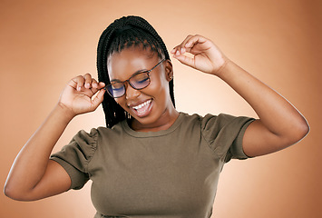 Image showing Happy, fashion or glasses with a carefree black woman in studio on a brown background for vision. Smile, style or eyewear and an attractive young female with a cheerful expression in frame spectacles