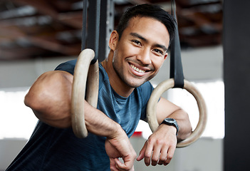 Image showing Portrait, gymnastic rings and olympics with a man gymnast hanging on equipment for workout in gym. Face, fitness and exercise with a male athlete training in gymnastics for health or power