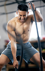 Image showing Fitness, battle ropes or strong man training for body goals in painful workout or exercise at a sports gym. Resilience, mindset or healthy athlete with biceps power, motivation or focus exercising