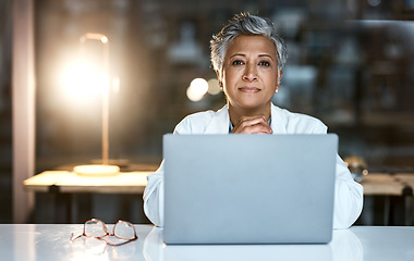 Image showing Doctor, laptop and portrait of senior woman in hospital working late or overtime on email, telehealth or research. Elderly, healthcare and confident female medical physician by computer at night.