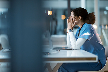 Image showing Nurse, burnout stress and black woman in hospital feeling pain, tired or sick on night shift. Healthcare, wellness and female medical physician with depression or anxiety while working late on laptop