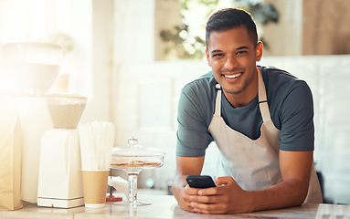 Image showing Barista, portrait and man with smartphone, smile and search online on break, connection and social media. Male employee, guy and worker in cafe, behind counter and cellphone for communication or text