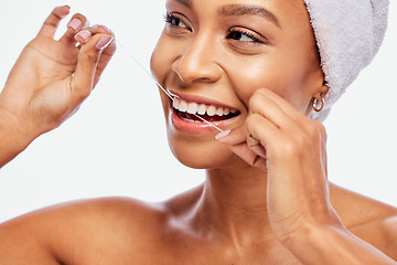 Image showing Face, hands and black woman flossing teeth, dental health and hygiene isolated on white background. Oral care product, floss and mouth cleaning for fresh breath in studio with happy model