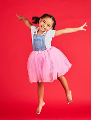 Image showing Portrait, girl and jumping in tutu skirt on red background, studio and fun fashion. Happy kid, ballet clothes and energy for performance, dance and smile with happiness, ballerina dress and princess