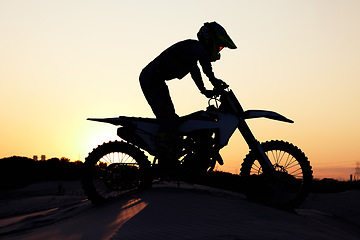 Image showing Silhouette, sports and motorcycle riding against sunset, sky and background in nature, extreme sport and adrenaline. Biking, motorbike and person driving on dirt road, sunrise and shadow or freedom