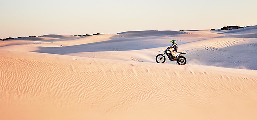 Image showing Desert, nature and athlete riding a motorcycle for exercise, fitness or skill training in nature. Extreme sports, action and male athlete on a bike for an outdoor workout in the sand dunes in Dubai.