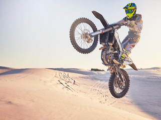 Image showing Motorcycle jump, sports outdoor with exercise in desert, stunt for extreme sport, speed and helmet for safety. Challenge, freedom and athlete biking, fitness mockup and person training with dirt bike