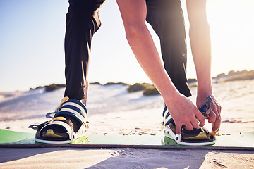 Image showing Sand, board and man tie shoes ready for desert surfing, extreme sports and action hobby in nature. Freedom, adventure and feet of athlete outdoors for fitness, exercise and dune surfer training