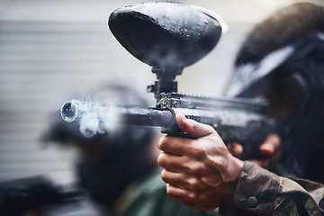 Image showing Hand, paintball and gun with a sports man playing a military game for training or fun outdoor. Fitness, exercise and safety with a male player using a marker to shoot during a competitive tournament