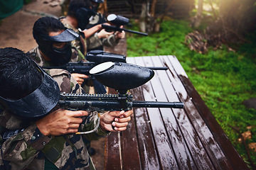 Image showing Paintball gun, men and games in rain for competition or sports challenge in military battle. Soldier, army or warrior people shooting paint target weapon in war training for battlefield protection