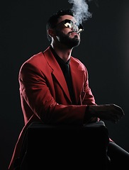 Image showing Man in red suit, smoking and fashion with style, trendy and guy on dark studio background. Mafia, male and gentleman with elegant outfit, edgy and cigarette with glamour, fancy and black backdrop