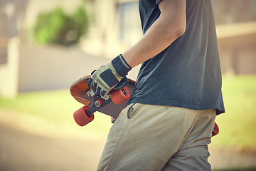 Image showing Fun, skateboard and man skateboarding in a neighborhood for fitness, exercise and training. Sport, cardio and hands of a teenager with a board in the street to travel, commute and playing in the road