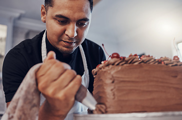 Image showing Piping, kitchen and man baking a cake with chocolate or pastry chef preparing a recipe at a bakery. Food, dessert and professional baker making a sweet meal and adds cream or icing