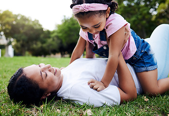 Image showing Mother, daughter and playing on grass, relax and laughing while bonding and having fun at a park. Mama, girl and game on a forest floor, joy and smile while enjoying a happy moment on the weekend