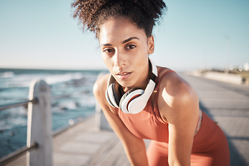Image showing Portrait, fitness and tired with a black woman runner on the promenade for cardio or endurance exercise. Running, workout or breathing with a young female athlete training outdoor by the sea