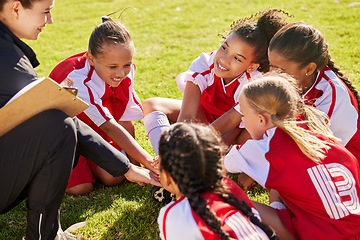 Image showing Girl soccer group, sitting and planning with coach on field with smile, team building or motivation at training. Female kids, sports diversity or happy with friends, teamwork or strategy for football