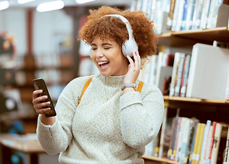 Image showing Black woman, phone and music in library with headphones, streaming and laugh for meme on web app. University student, funny blog or social media with smile, smartphone and learning for education goal