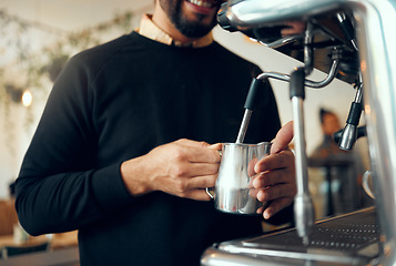 Image showing Hands, barista and brewing coffee in kitchen using machine for hot beverage, caffeine or steam. Hand of employee male steaming milk in metal jug for premium grade drink or self service at cafe