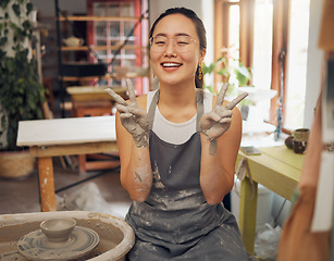 Image showing Pottery, peace and clay hands portrait of woman in workshop for small business art class. Asian person with happy emoji for wheel production or spinning as creative motivation, support and success.