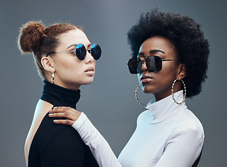 Image showing Fashion, friends and women with sunglasses in studio for cosmetics, makeup and futuristic style. Luxury models, designer brand and confident girls with stylish accessory, trendy clothes and jewellery