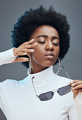 Image showing Fashion, cosmetics and black woman with sunglasses in studio for stylish clothes, makeup and luxury style. Beauty model, designer brand and confident girl with accessories, trendy and edgy jewellery