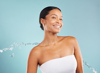 Image showing Water splash, black woman and beauty portrait in studio for cleaning cosmetics on blue background. Face of happy female model, shower drops and healthy skincare for body wellness, aesthetic and smile