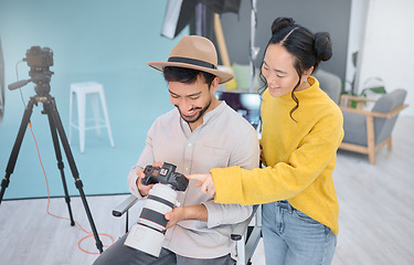 Image showing Photography, photographer and model in discussion with a camera choosing a image from the photoshoot. Creative, art and young cameraman talking to woman to choose the best picture in artistic studio.